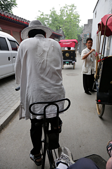 Beijing - Rickshaw driver peddling us along in the Hatung district