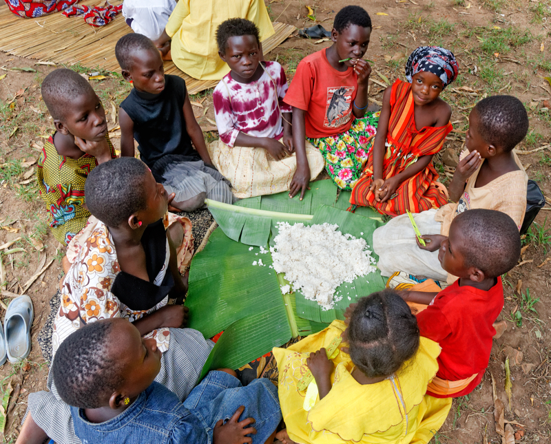 A Spiritual Experience in Africa - Girls eating lunch on banana leaf plates. - Meals are held communally on special occasions. Following local custom, men, women, girls and boys each dine in their own independent groups.