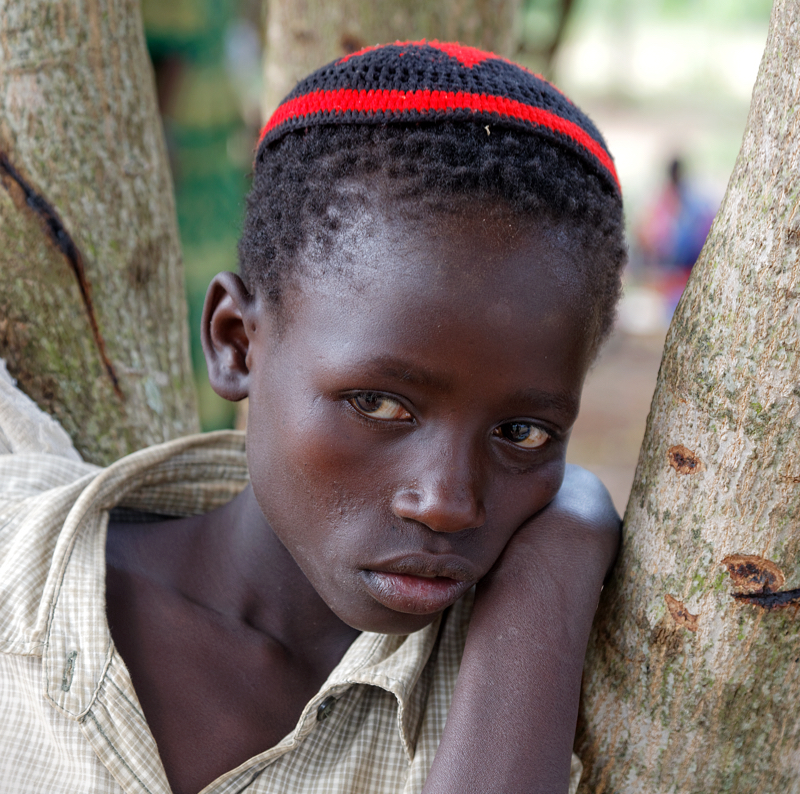 A Spiritual Experience in Africa - Portrait of a young boy, deep in thought, under one of the many trees in the Putti Village common area. Located just one dregree north of the equator, this region, in most years, recieves abundant rainfall.